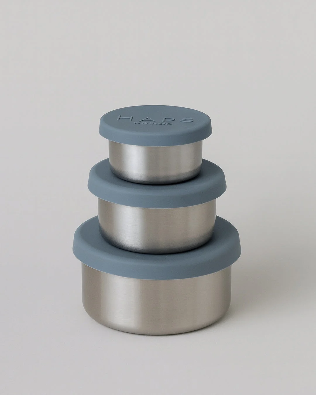 I tre contenitori rotondi in acciaio inox Steel Trio Small da 50, 110 e 220 ml con coperchi in silicone blu Ocean