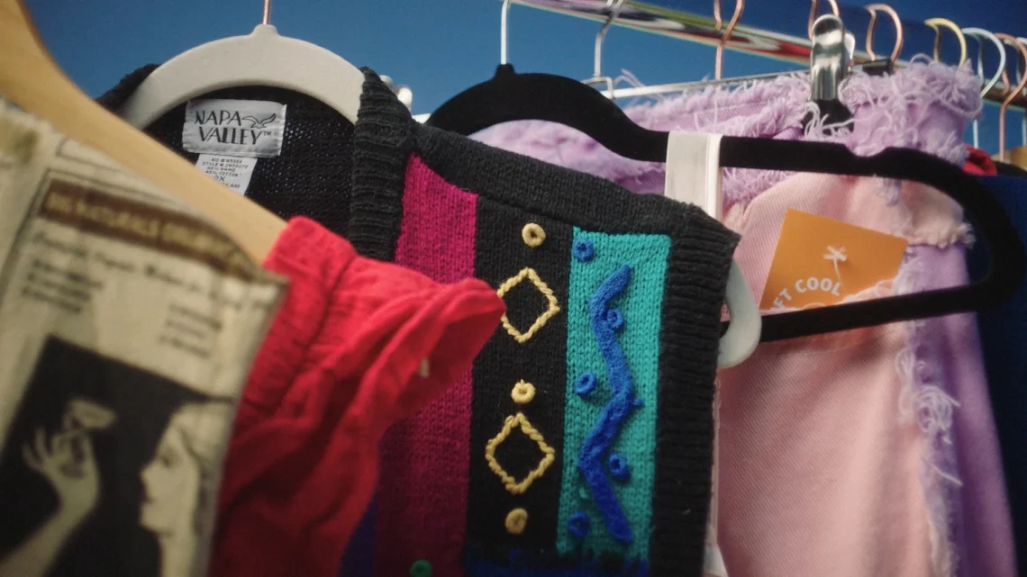 Capi di abbigliamento vintage e merchandise locale appesi su una gruccia, a rappresentare la tendenza Caccia al Merch di Skyscanner
