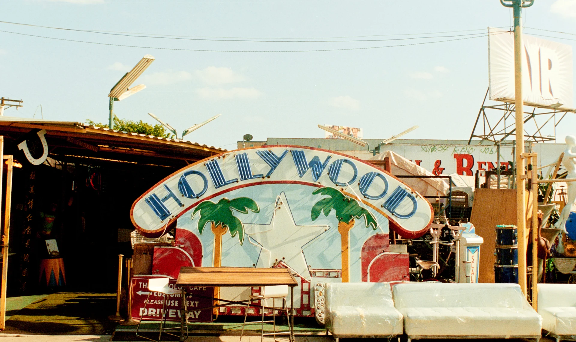 Insegna vintage al neon Hollywood tra pezzi d'arredo e memorabilia in un mercatino delle pulci