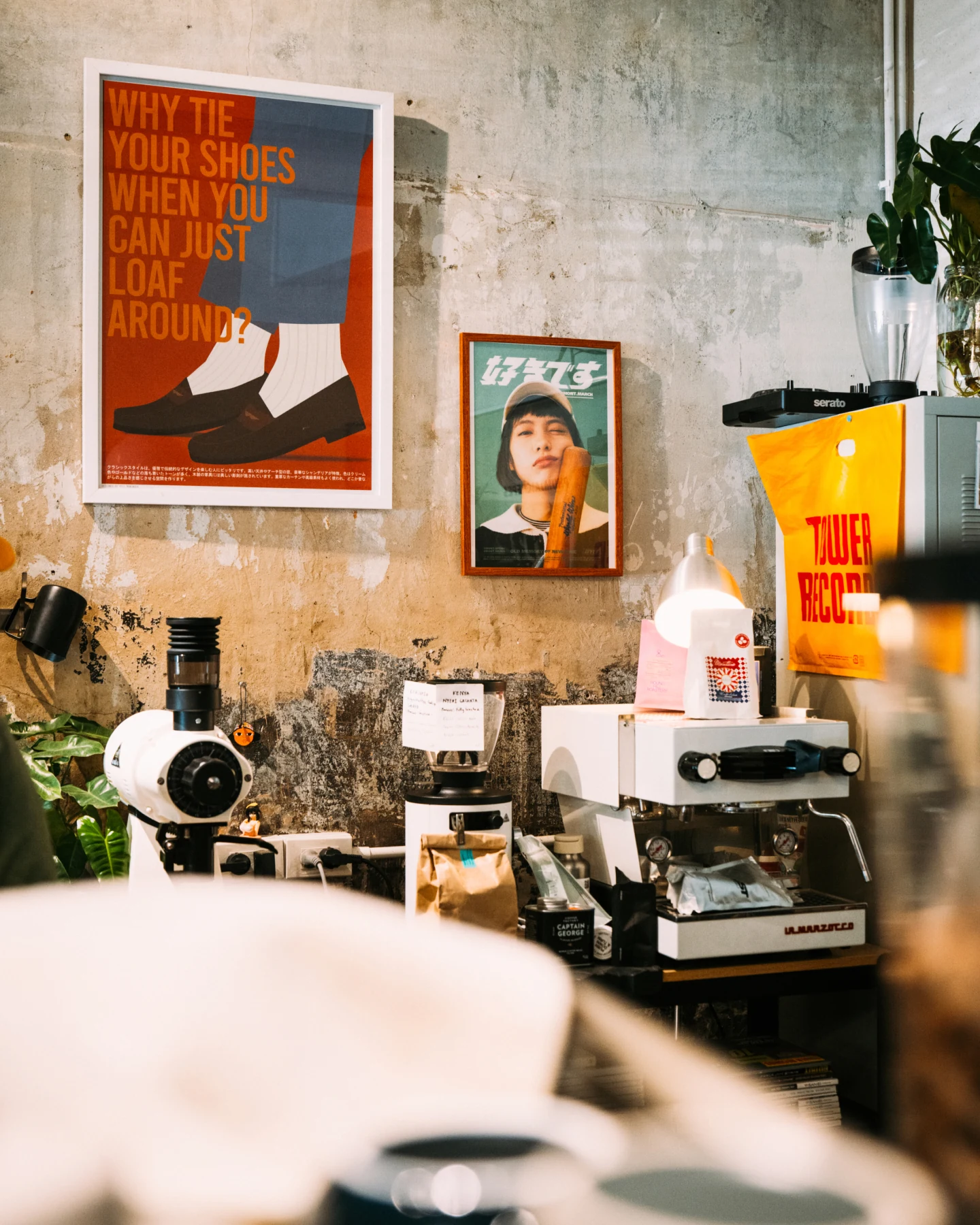 Bottega specialty coffee con macchine artigianali, poster vintage e borse promozionali a testimoniare la scoperta di luoghi insider